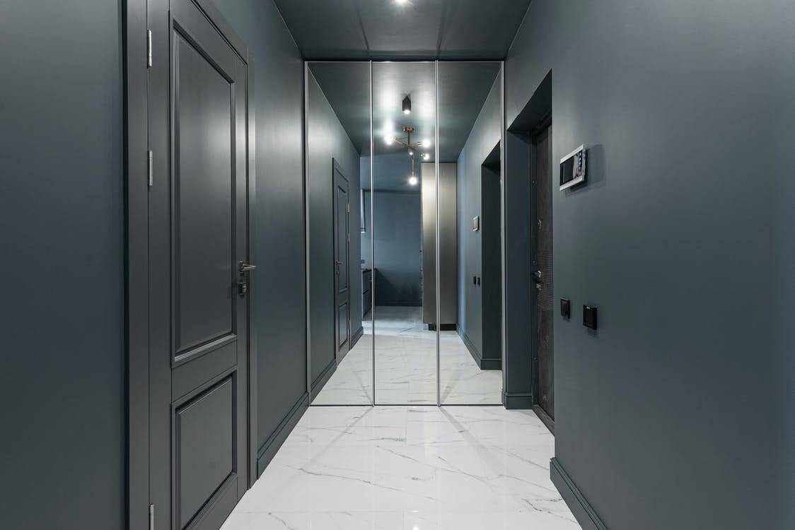 orridor of modern apartment with doors and mirror